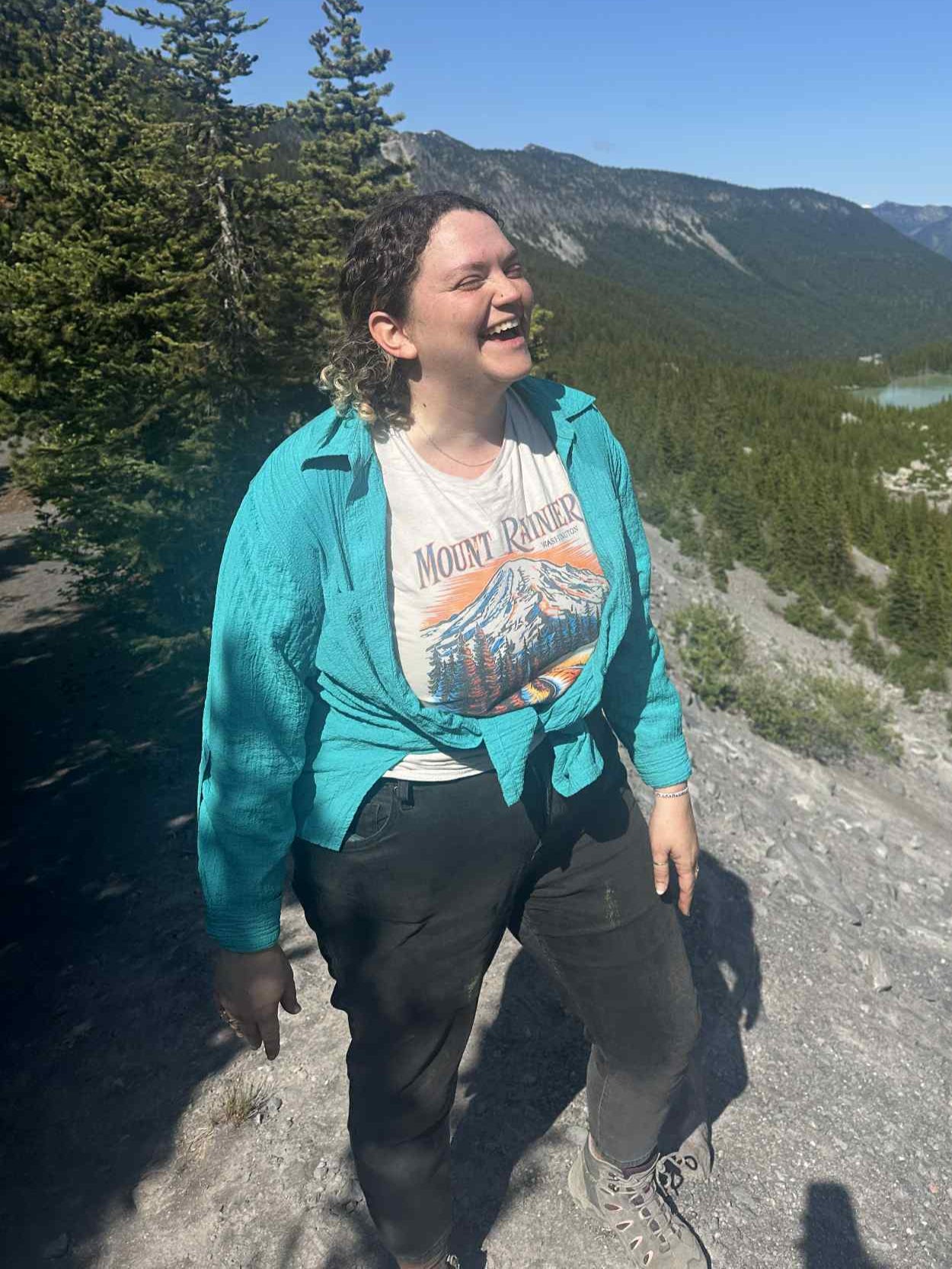 Person standing on a mountain trail with scenic view