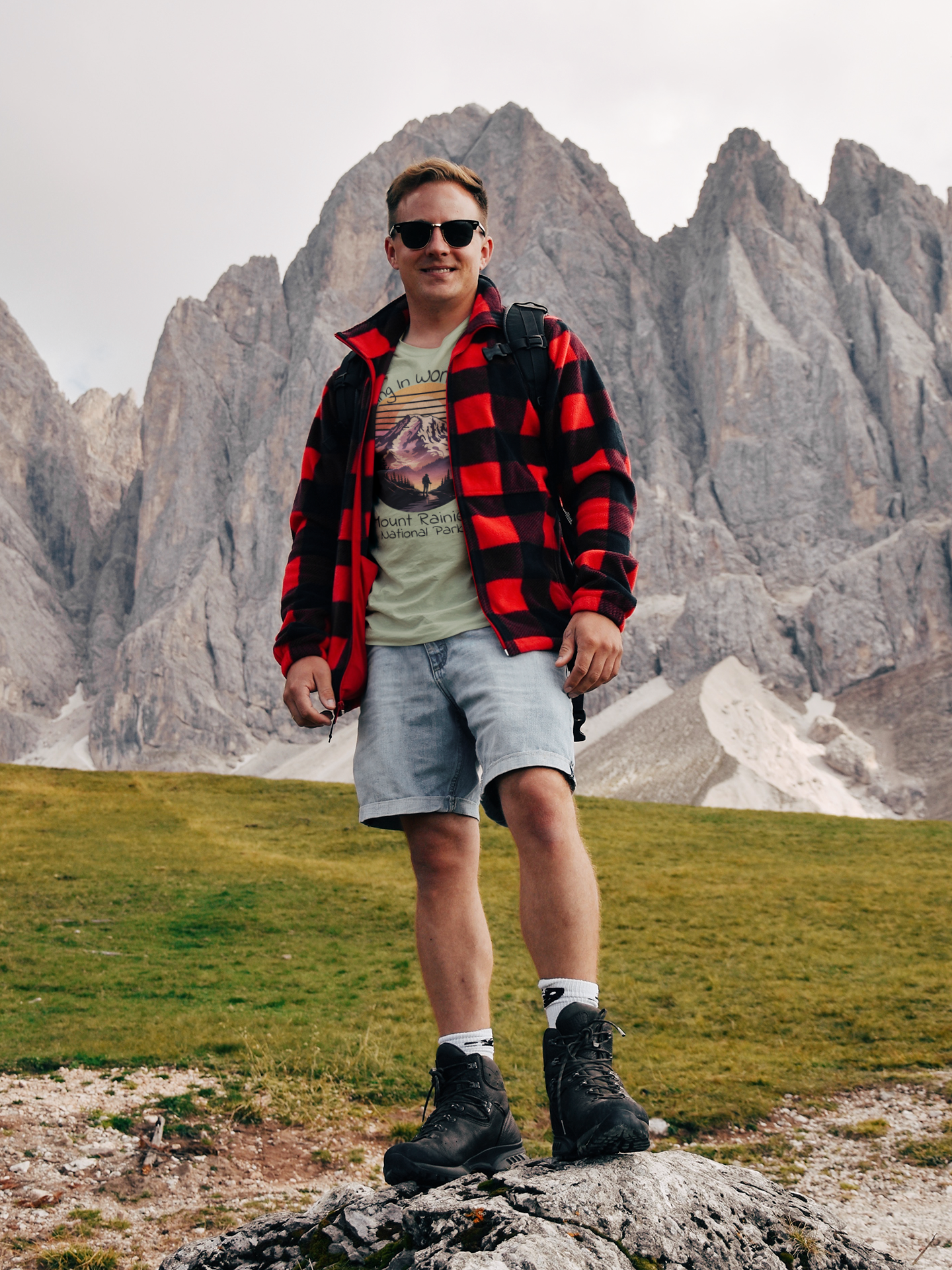 Person standing on a rocky outcrop with mountainous landscape in the background