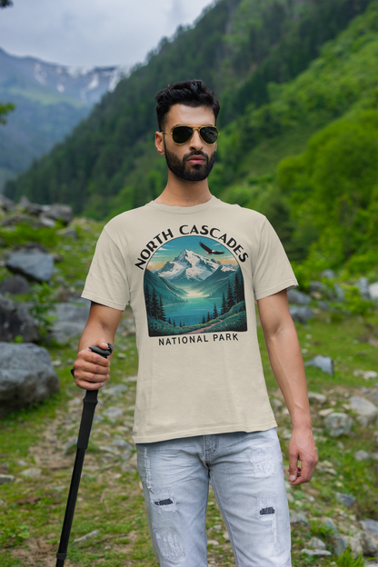 Man wearing a t-shirt with 'North Cascades National Park' design in a mountainous landscape.