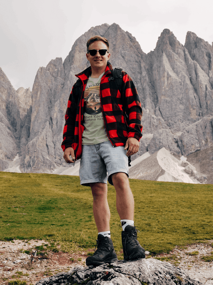 Person standing on a rocky outcrop with mountainous landscape in the background