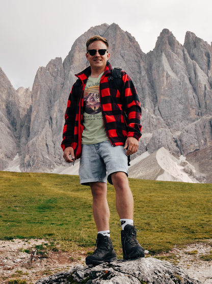 Person standing on a rocky outcrop with mountainous landscape in the background